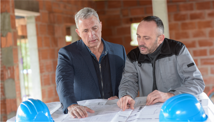 Architect and contractor looking at plans on a building site